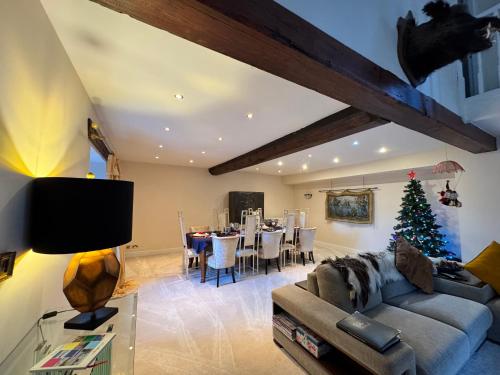 a living room with a couch and a christmas tree at WestLaigh Lrg Luxury Country Farm House 20 min from the city in Glassford
