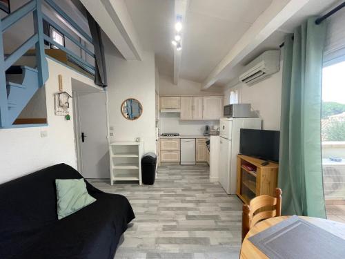 une petite cuisine avec un canapé et une table dans l'établissement Location Cap Agde Pinede, au Cap d'Agde