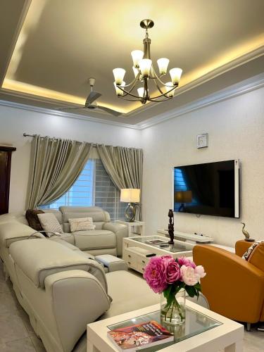 a living room with a couch and a tv at The African Palace- Free Airport Pick up - High Speed Starlink WiFi - Car Rental in Tamale