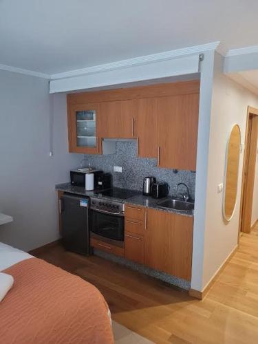 a kitchen with a sink and a stove top oven at Nagale in Vigo