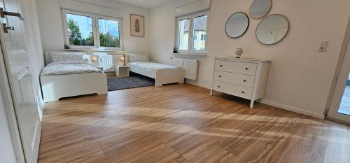 a room with two beds and a dresser and mirrors at Ferienwohnung Schuller in Gottmadingen