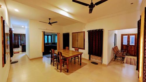 a dining room with a wooden table and chairs at Ambady Plantation Residency in Thekkady