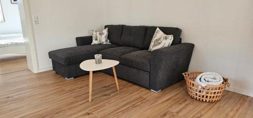 a living room with a black couch and a table at Ferienwohnung Schuller in Gottmadingen