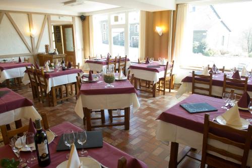 a restaurant with tables and chairs with wine glasses at Auberge Saint-Martin in Orchimont