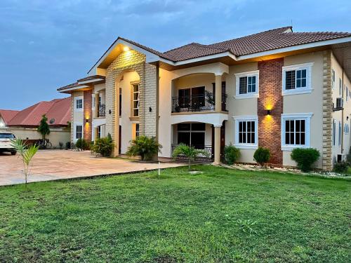 a house with a lawn in front of it at The African Palace- Free Airport Pick up - High Speed Starlink WiFi - Car Rental in Tamale