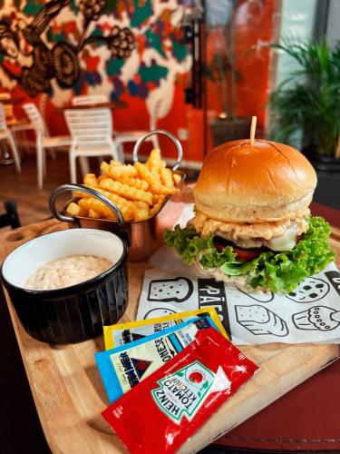 a sandwich and french fries and a cup of dip at Royal Design Savassi Hotel in Belo Horizonte