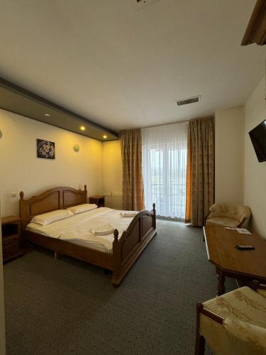 a bedroom with a large bed and a window at Hotel Veștem in Veştem