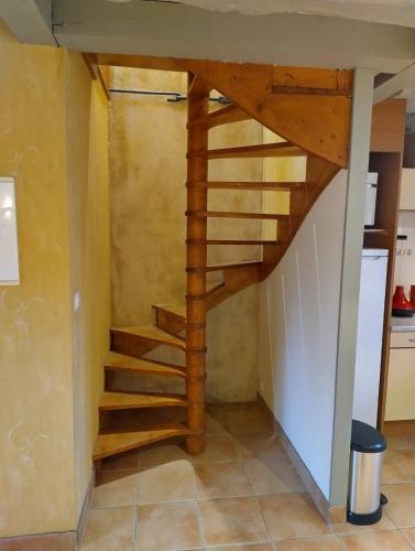 a spiral staircase in a kitchen with a stairway in a house at Petite Maison à côté de la Forêt de Rennes in Betton