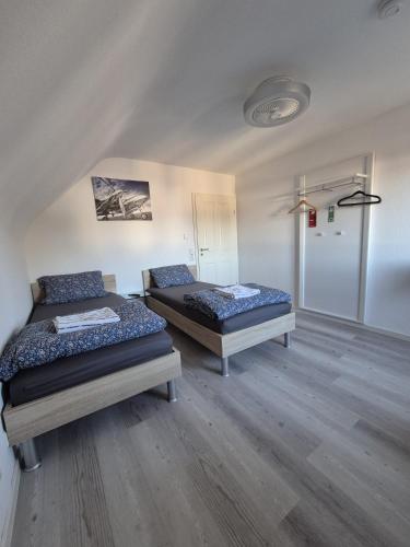 two beds in a room with wooden floors at Dasluki in Köngen