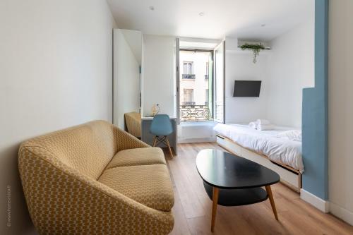 una sala de estar con un sofá y una cama en Studio lumineux proche Paris Vincennes, en Saint-Mandé