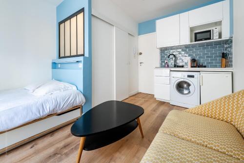 une petite pièce avec un lit et une table dans l'établissement Studio lumineux proche Paris Vincennes, à Saint-Mandé