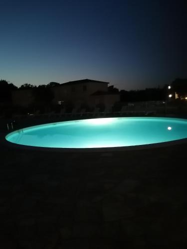 une piscine éclairée la nuit dans l'établissement Santa Maria Poggio, à Moriani-Plage