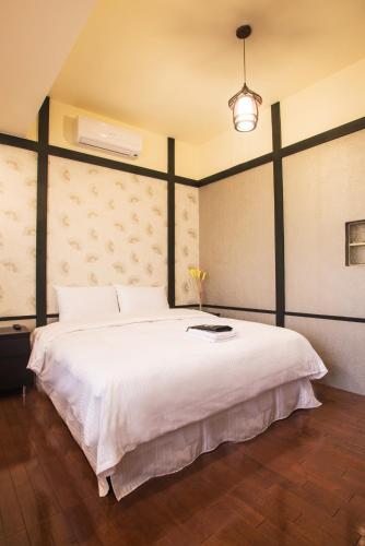 a bedroom with a large white bed in a room at Hananoi Bed and Breakfast in Hengchun