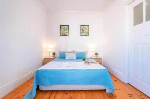 a bedroom with a blue and white bed and two lamps at Host Wise - Spacious Comfortable Apartment - Balcony in Porto