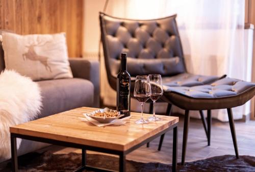 a living room with a couch and a table with wine glasses at Alpenblick in Brixen im Thale