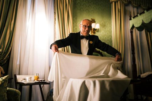 a man in a tuxedo standing in a bed at Hotel Al Ponte Dei Sospiri in Venice