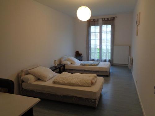 een kamer met twee bedden en een raam bij Vacances a St Germain d Esteuil 33340 in Saint-Germain-dʼEsteuil