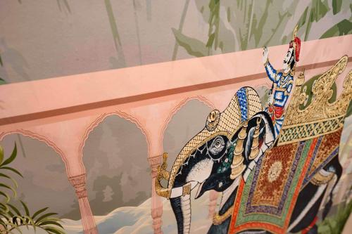 a painting of a dragon on a wall at Majestic Inn in Pune