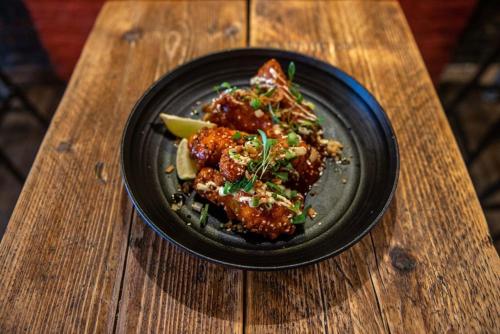 a black plate of food on a wooden table at Majestic Modern Flat in the heart of London in London