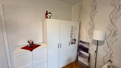 a room with a white cabinet and a lamp at Ferienwohnung Frankenhäuser in Schwerte