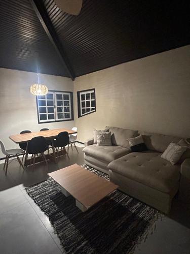 a living room with a couch and a table at Casa estilosa na rua principal de Búzios in Búzios