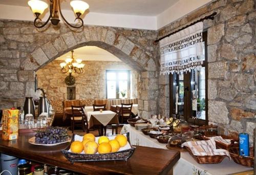 a kitchen with a table with fruits on it at Meterizi Guesthouse in Varvítsa