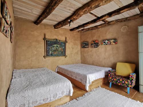 a bedroom with two beds and a yellow chair at Вила 'Гнездото', Villa 'The nest', Rhodope mountains, Banite in Vishnevo
