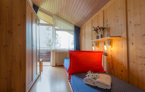a room with a bed with a red pillow at Appartamento Hubertus 2 camere in Riscone