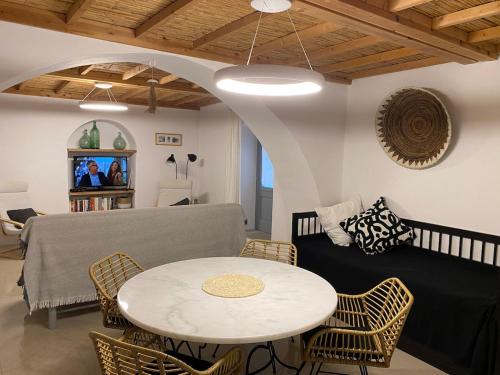 a living room with a table and a couch at KERYLOS , au cœur de Parikia, avec jardin in Parikia