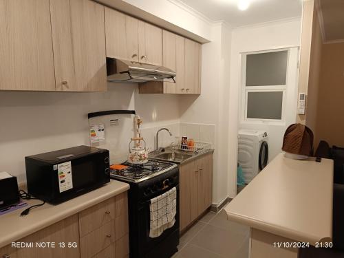 una cucina con forno a microonde e fornello forno superiore di Departamento en excelente lugar para descansar a Puerto Montt