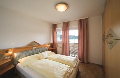 una camera da letto con un letto con una grande finestra di Maltschacher Seewirt a Feldkirchen in Kärnten
