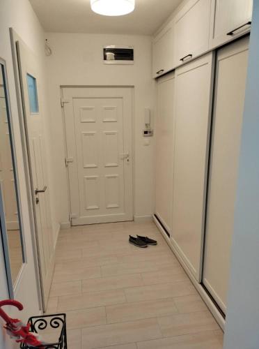 ペーチにあるFreedom 50 Apartmanの白いドアと靴を履いた廊下