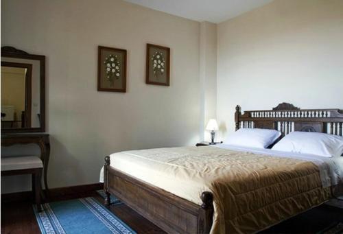 1 dormitorio con 1 cama grande y espejo en Meterizi Guesthouse, en Varvítsa