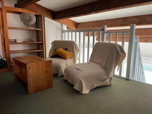 deux chaises et une table dans une pièce dans l'établissement Appartement T3 avec Piscine, Climatisation et Parking à 350m de la Plage - Capacité 4 Personnes - FR-1-749-34, au Cap d'Agde
