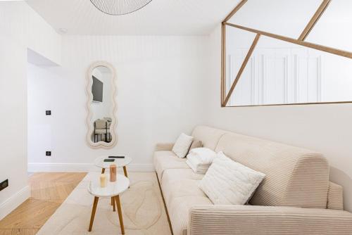 un salon blanc avec un canapé et une table dans l'établissement Suite luxueuse Elysee Faubourg St Honore Paris 8, à Paris