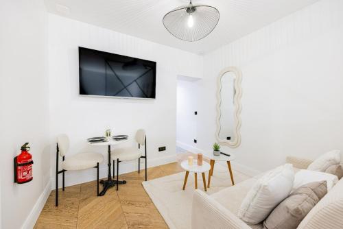 un salon blanc avec un canapé blanc et une table dans l'établissement Suite luxueuse Elysee Faubourg St Honore Paris 8, à Paris