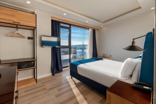 イスタンブールにあるUnion Hotel Karaköyのベッドと大きな窓があるホテルの部屋