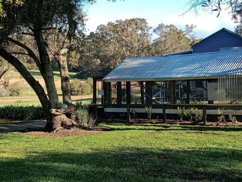una casa con techo solar y un árbol en Redtail Ridge Cottages, en Hester