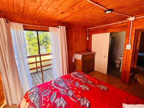 a bedroom with a bed and a large window at Casa Eco Bosque in Pichilemu