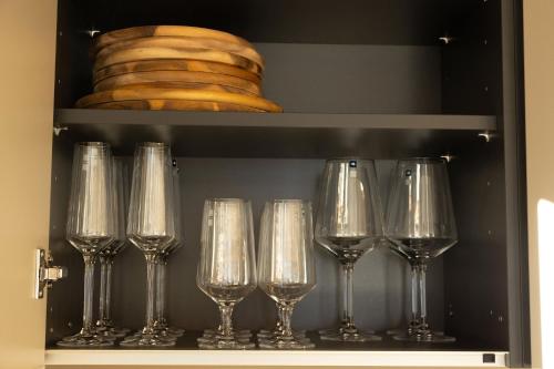 a row of wine glasses sitting on a shelf at Adlerblick Deluxe Annenheim in Annenheim