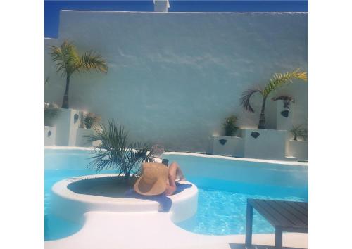 a woman sitting in a tub next to a swimming pool at Natural Renacer Zen Baby Package Included in Corralejo