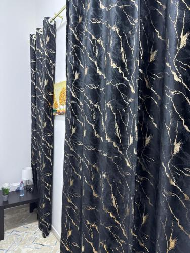 a black and gold shower curtain in a room at Four Stars Residence in Dubai
