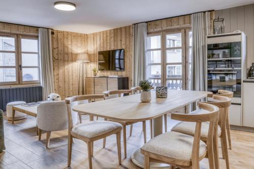 une cuisine et une salle à manger avec une table et des chaises dans l'établissement Écrin de raffinement au cœur de Megève, à Megève