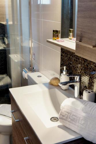 a bathroom with a sink and a shower at Angela Apartments in Kato Daratso