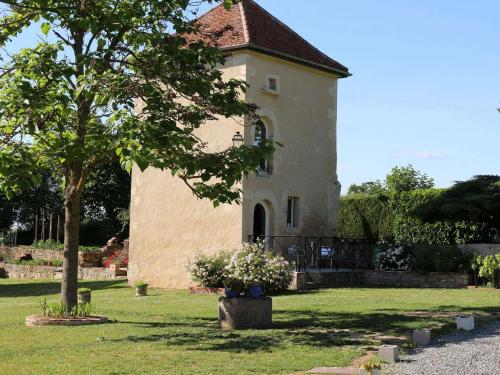 a small building with a tree in the yard at Gites de Gondières in Saint-Éloi