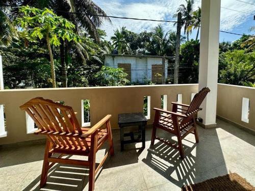 two chairs and a table on a porch at Siyon Yula - Guest House in Hikkaduwa