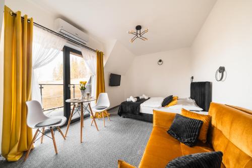 a bedroom with a bed and a couch and a window at Siedmiu Króli Rooms&SPA in Bukowina Tatrzańska