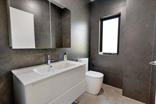 a bathroom with a white sink and a toilet at Sunset House in Raymond Island