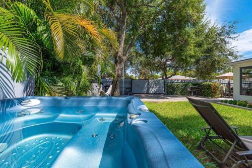 a blue plunge pool in a yard with a chair at Renovated 2BR Home - Hot Tub, Gym & Beach Nearby in West Palm Beach