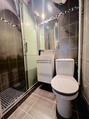 une salle de bain avec des toilettes blanches et une douche dans l'établissement L'Eiffel - Charmant studio proche Tour Eiffel, à Paris